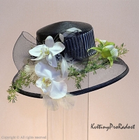 Svatební klobouk je zdoben bílým phanelopsis a zeleným květem orchidee paphiopedillum.