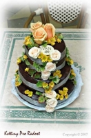 Svatební dort, zdobený živými květinami, barevně ladil se svatební kyticí nevěsty.
