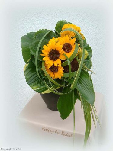 Jednoduchá svatební kytice z květů slunečnic, doplněná zelení. 