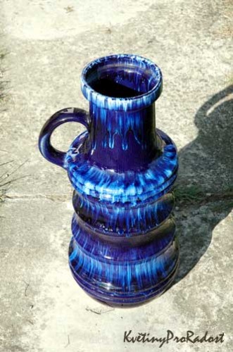 Neobvyklá modrá váza s uchem, vhodná do stylového interiéru.