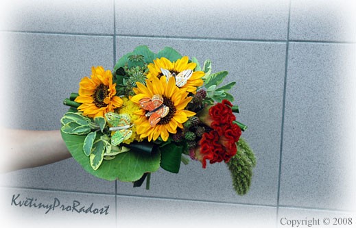 Letní kytice pro malé slečny v níž dominují žluté slunečnice, zvýrazněné červenou barvou celosií. Letní atmosféru připomínají plody ostružin a makovic. 
