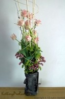 Tmavá váza nezvyklá tvarem i materiálem a světle růžové tulipány  vytváří zajímavý kontrast této jarní kytice.